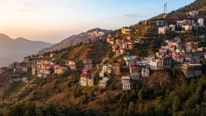Aerial view of colorful buildings on Shimla hills during sunrise in Himachal Pradesh, India.
