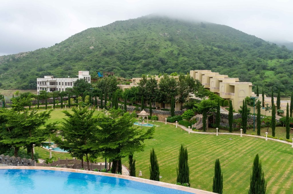 Stunning view of a resort amidst lush greenery and hills in Kumbhalgarh, Rajasthan.
