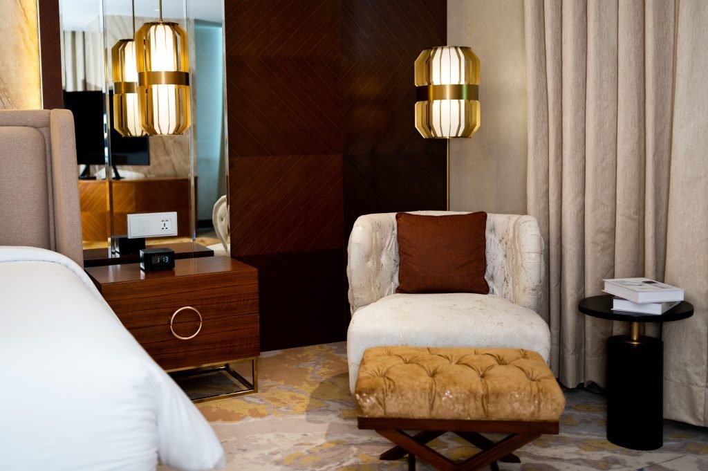 Luxurious hotel room with plush seating, bedside table, and stylish lighting in Islamabad.
